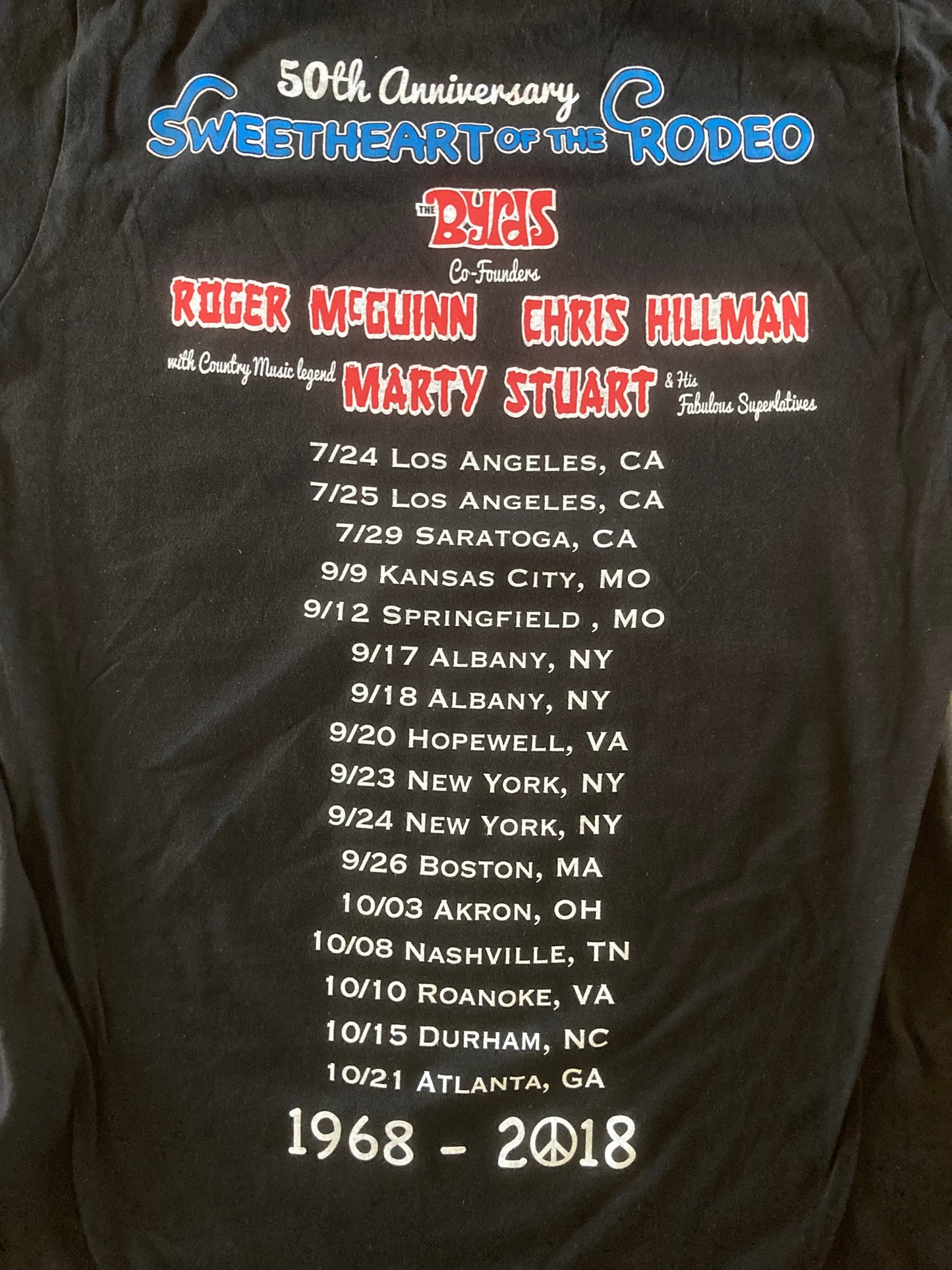 Black t-shirt with event details and names printed on a dark surface