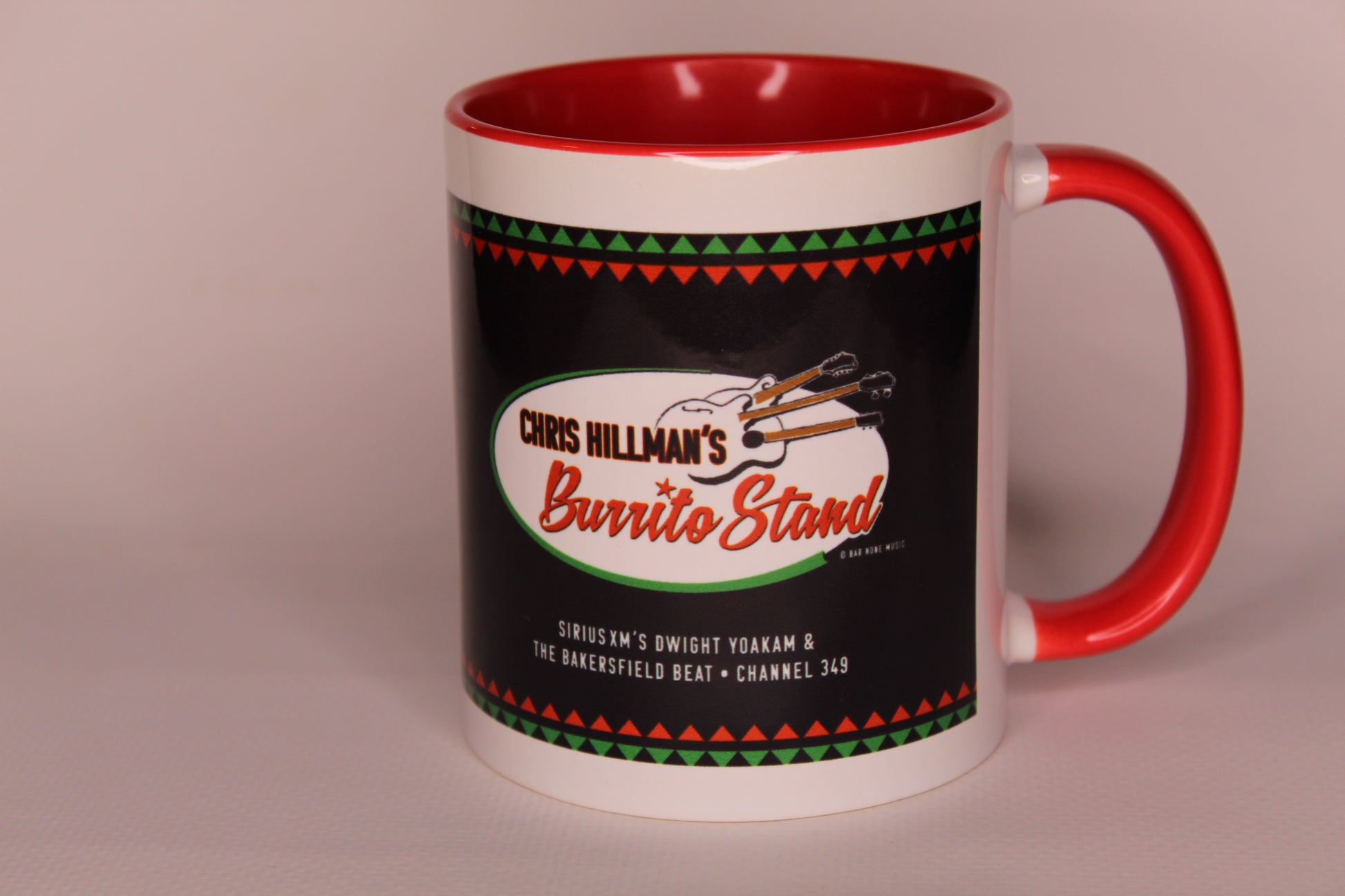 A ceramic mug with a white exterior, red interior and handle, and a black wraparound graphic featuring the text 'Chris Hillman's Burrito Stand' with a stylized guitar graphic.