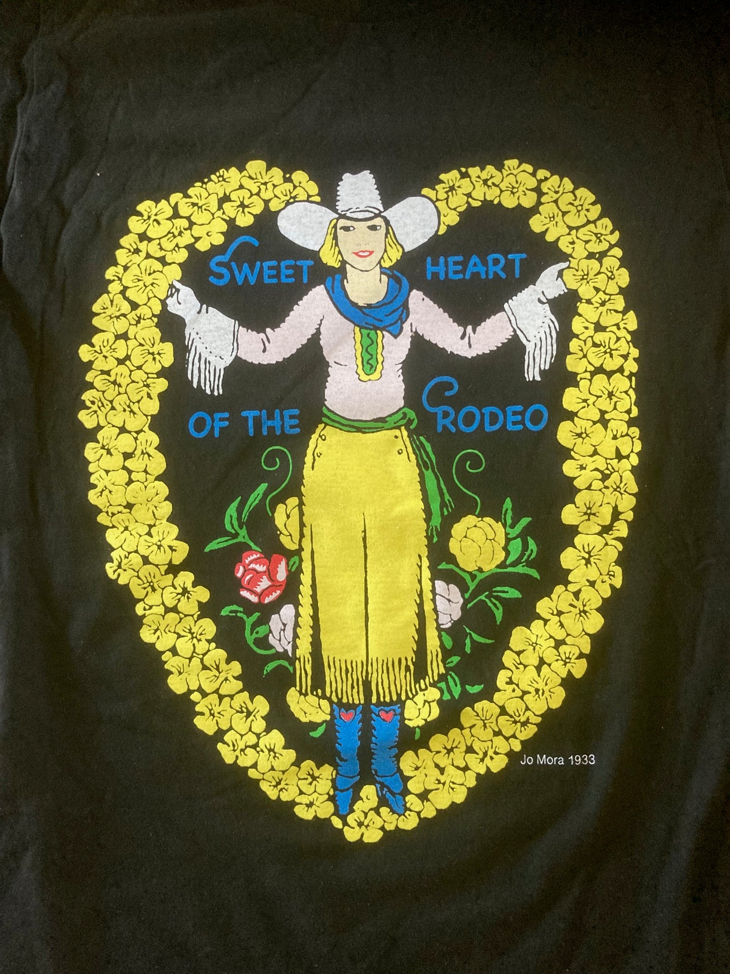 Embroidered design on a black background featuring a cowboy and floral elements.