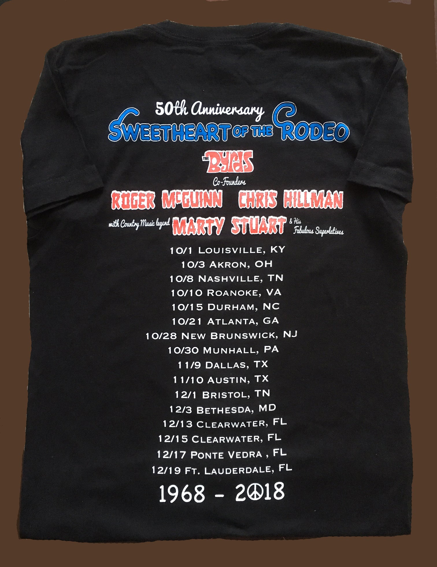 Black t-shirt with '50th Anniversary Sweetheart of the Rodeo' text and event details on a brown background
